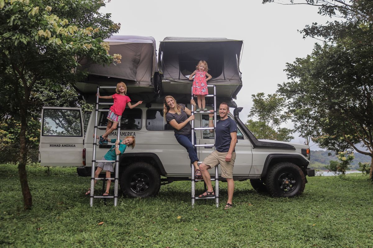 Family beside a Toyota Land Cruiser Troopie with two rooftop tents open