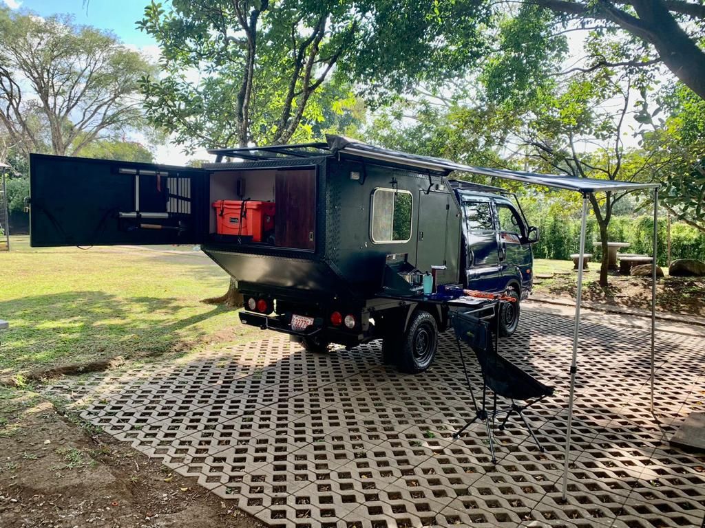 Kia Bongo 4x4 camper with its back doors open and side awning out