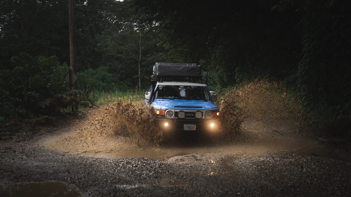 Toyota FJ Cruiser driving through mud on a forest track