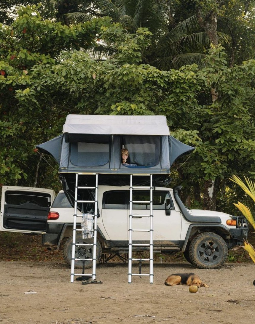 Toyota FJ Cruiser with the wide double rooftop tent open and two ladders