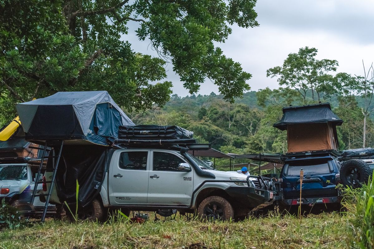 Toyota Hilux with rooftop tents open at a hillside campsite